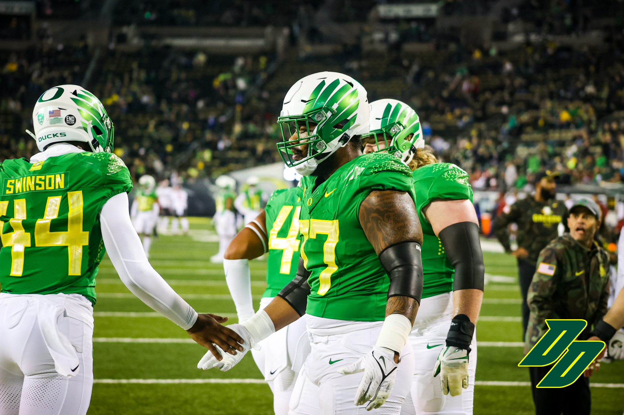 Moore high fives teammate Bradyn Swinson as the Ducks go through pre game warmups vs. Washington State.